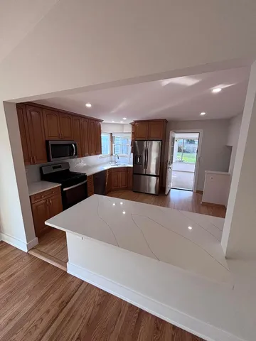 a kitchen with stainless steel appliances a refrigerator sink and microwave