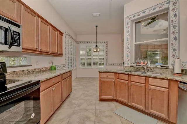 a kitchen with granite countertop stainless steel appliances stove sink and cabinets