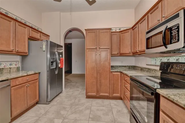 a kitchen with stainless steel appliances granite countertop a stove refrigerator and cabinets