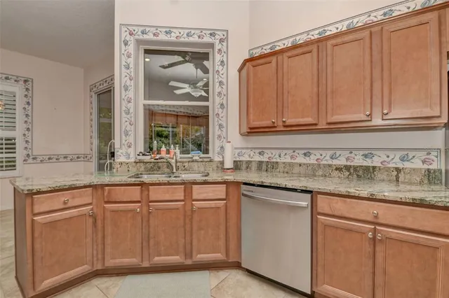 a kitchen with white cabinets and sink