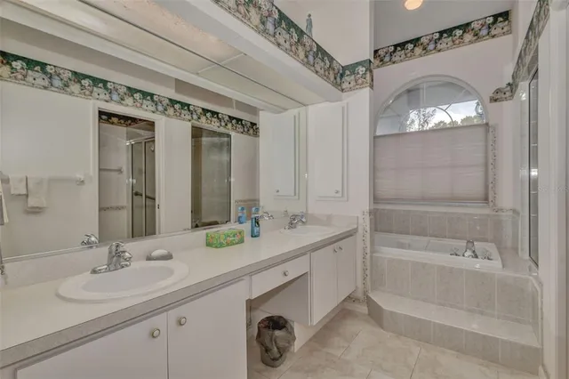 a bathroom with a double vanity sink mirror and bathtub