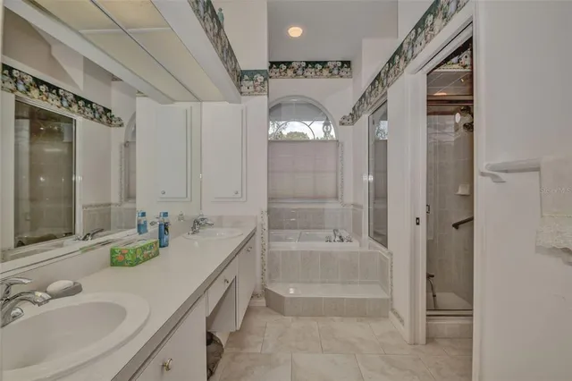 a spacious bathroom with a granite countertop tub sink a mirror and shower