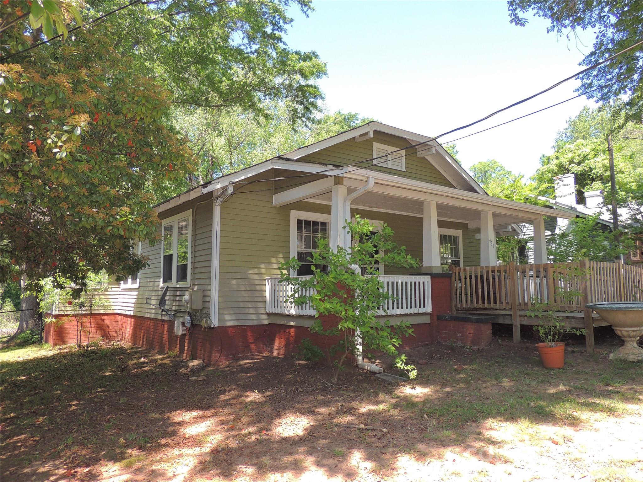 431 North Main Street Rutherfordton, NC 28139 - Photo 1 of 33 a view of a house with a yard chairs and floor to ceiling window and wooden fence