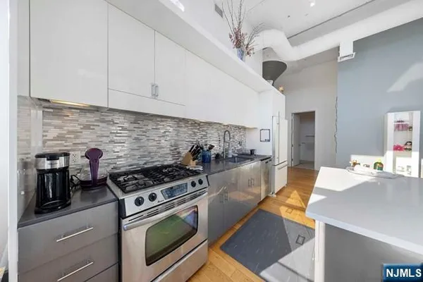a kitchen with stainless steel appliances kitchen island a stove a sink and a refrigerator