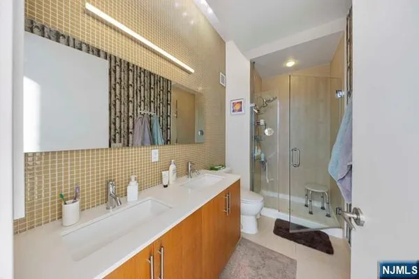 a bathroom with a sink double vanity mirror and a shower