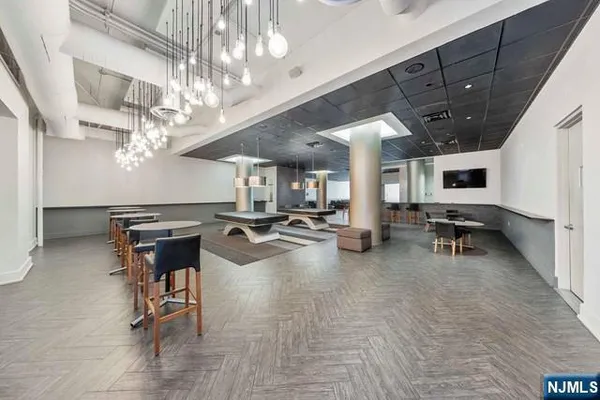 a view of a room with gym equipment and a chandelier