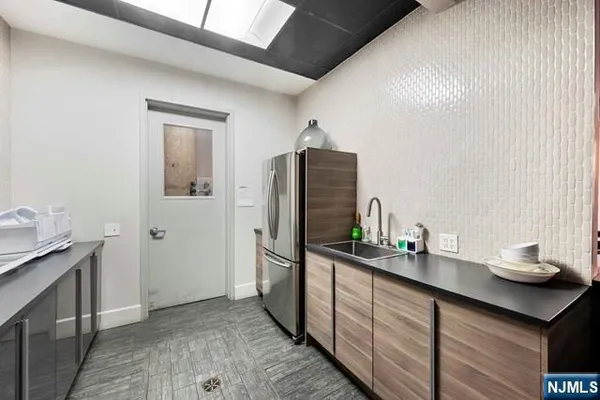 a kitchen with granite countertop a sink and refrigerator