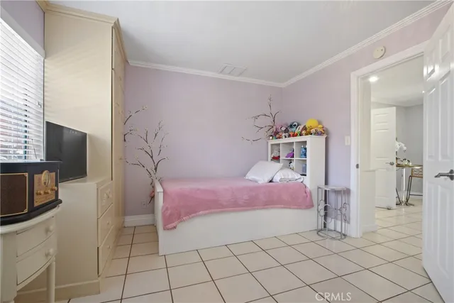 a bedroom with a bed a flat screen tv and dresser