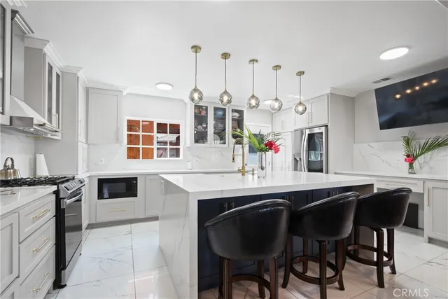 a kitchen with stainless steel appliances kitchen island granite countertop a stove a sink and a refrigerator