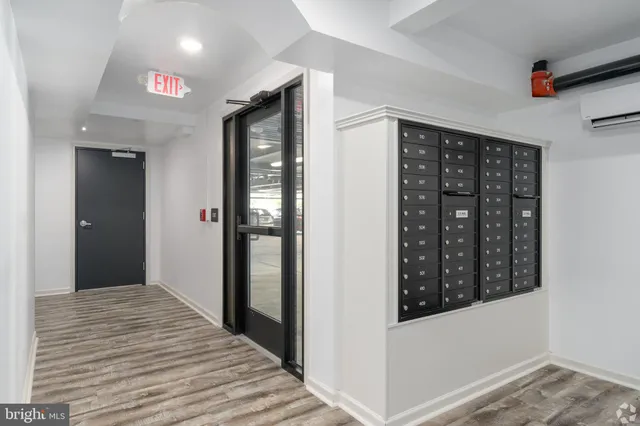 a view of a hallway with wooden floor and cabinet