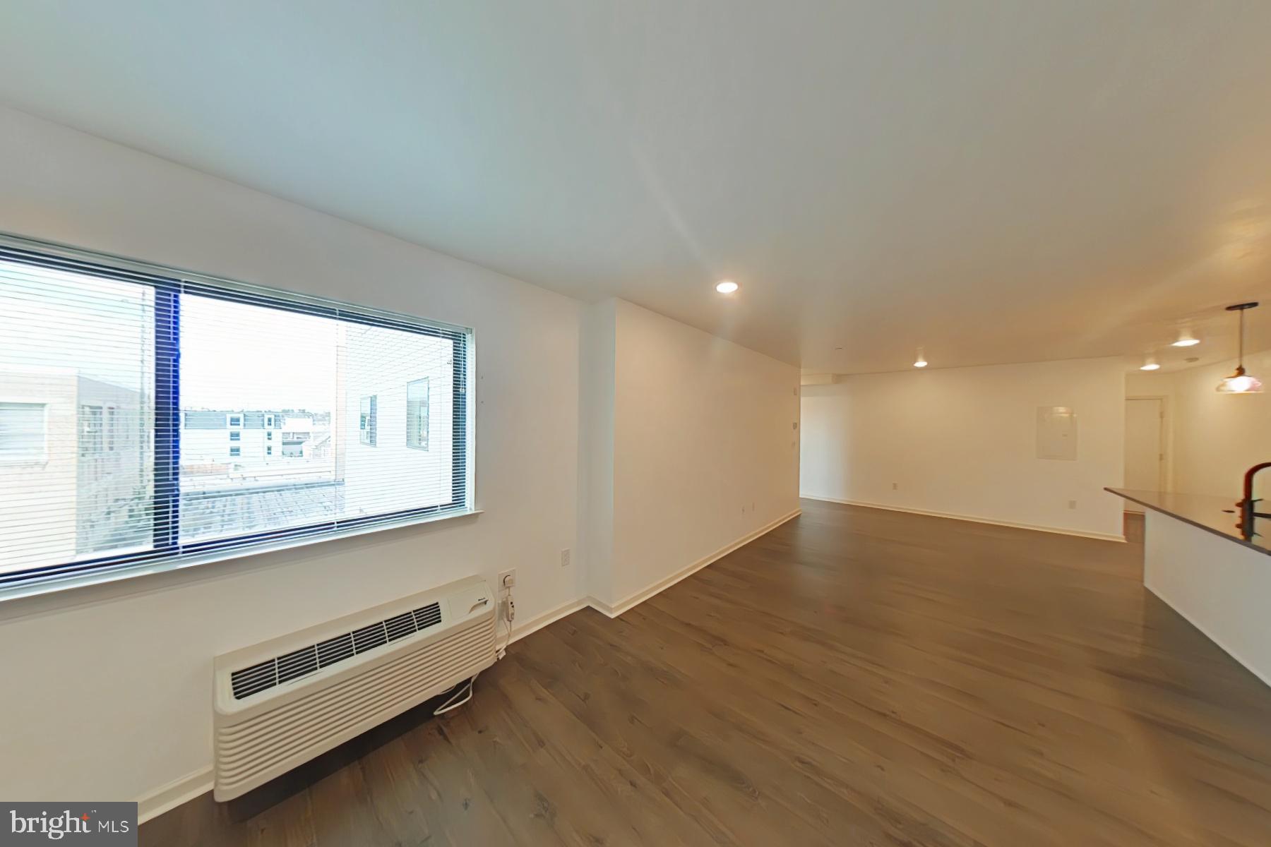 6618 Ridge Avenue, Unit 307 Philadelphia, PA 19128 - Photo 8 of 15 an empty room with wooden floor and windows