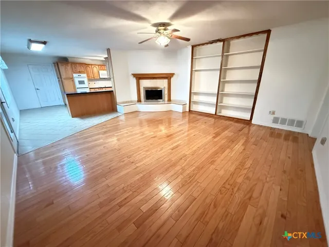wooden floor in an empty room with a fireplace