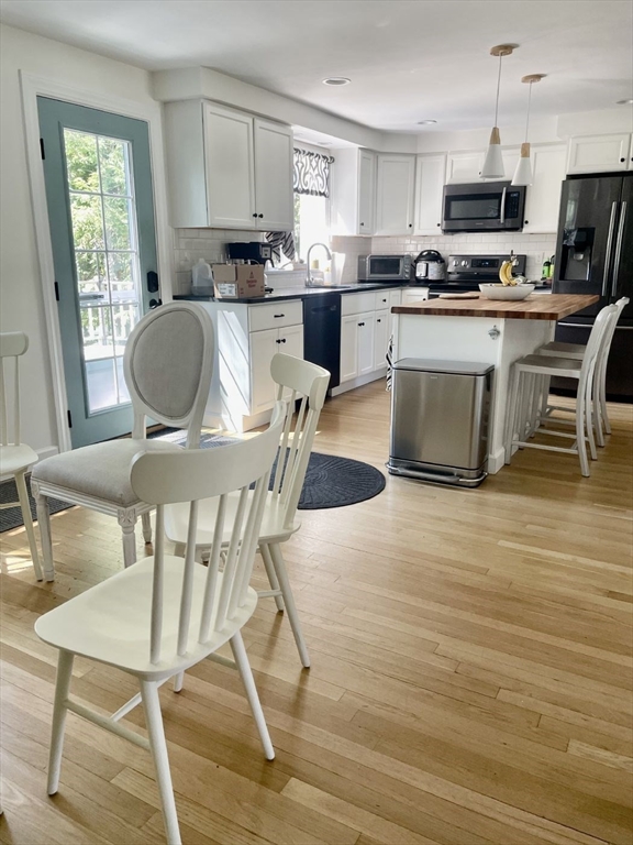 4 Carter Road Woburn, MA 01801 - Photo 12 of 28 a kitchen with stainless steel appliances granite countertop a stove top oven a sink a dining table and chairs
