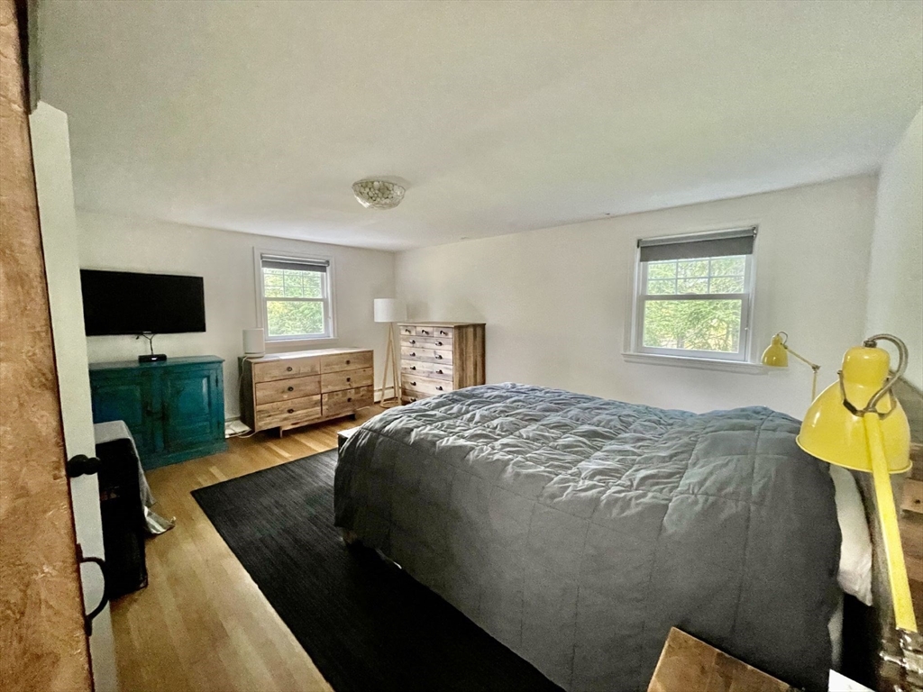 4 Carter Road Woburn, MA 01801 - Photo 17 of 28 a bedroom with a bed and flat tv screen on the dresser
