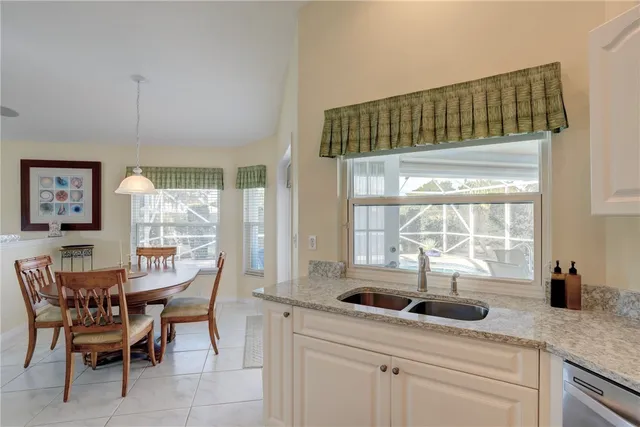 a kitchen with a table chairs and white cabinets