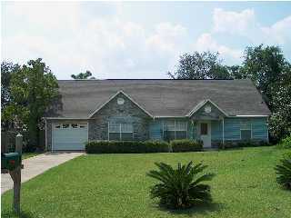 2804 Mac Gregor Lane Crestview, FL 32539 - Photo 1 of 3 a front view of a house with a garden