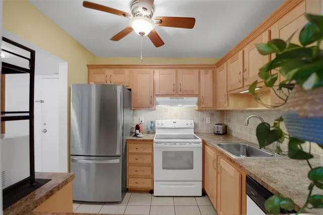 a kitchen with cabinets stainless steel appliances and a counter space