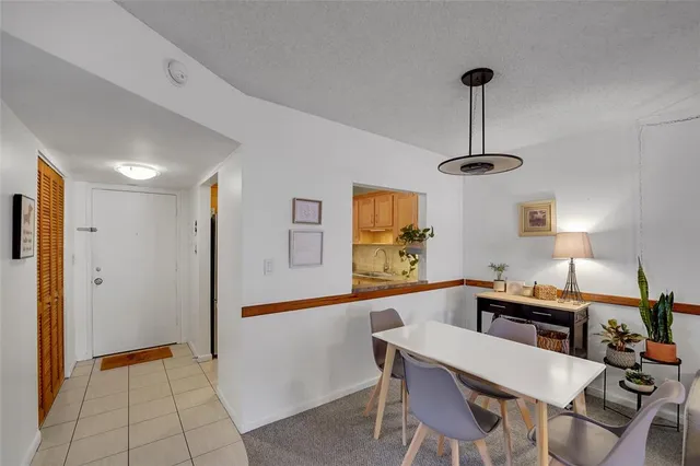 a view of a dining room and a kitchen with a table chairs