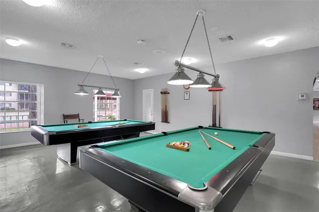 a room with pool table and windows