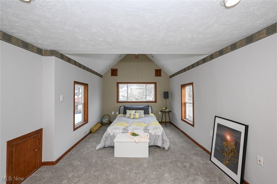 1164 Copley Road Akron, OH 44320 - Photo 29 of 50 Bedroom featuring light carpet, vaulted ceiling, a textured ceiling, and baseboards