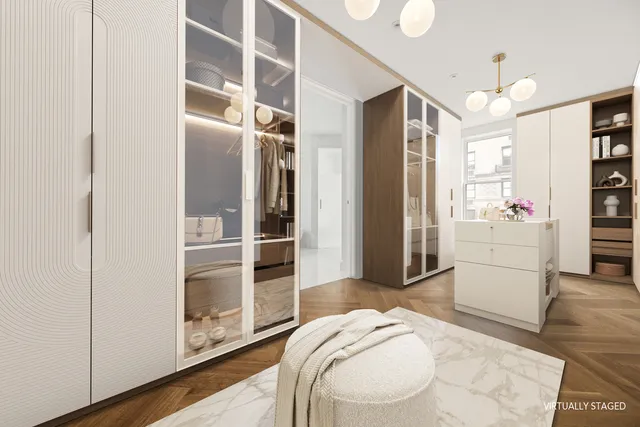 a spacious bedroom with a bed a couch and a chandelier