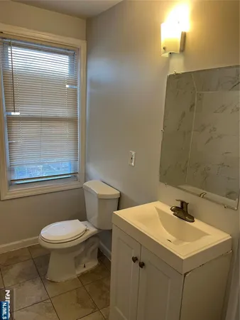 a bathroom with a sink a toilet and a mirror
