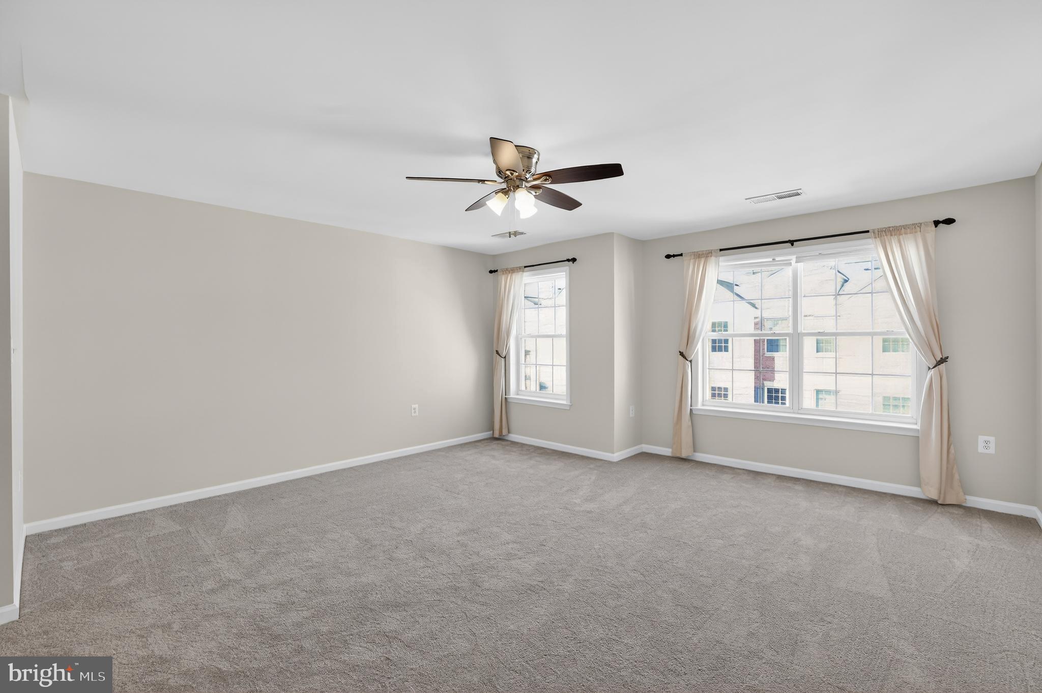 2228 Highfly Terrace, Unit 2228 Silver Spring, MD 20902 - Photo 21 of 35 an empty room with chandelier fan and windows