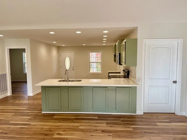 an empty room with wooden floor chandelier fan and windows