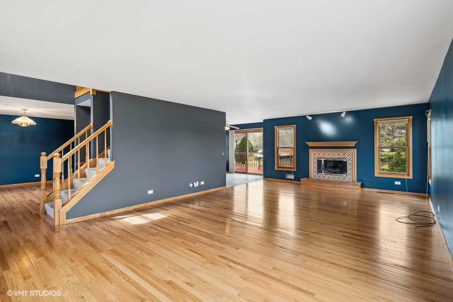 1502 Pine Street Spring Grove, IL 60081 - Photo 3 of 29 a view of an empty room with wooden floor and a fireplace