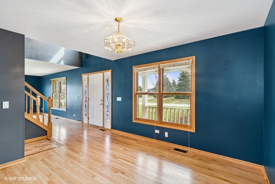 1502 Pine Street Spring Grove, IL 60081 - Photo 5 of 29 a view of an empty room with wooden floor and a window