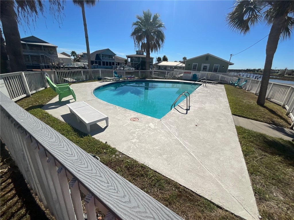 2290 North Fulton Beach Road, Unit B319 Rockport, TX 78382 - Photo 4 of 7 a view of a swimming pool with couches chairs and wooden floor