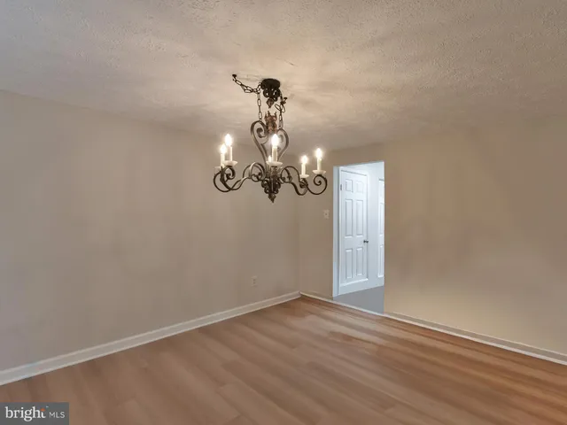 a view of a room with wooden floor and ceiling fan