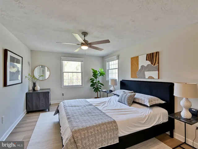 a bedroom with a large bed a chandelier and dresser