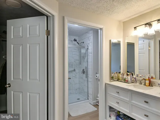 a bathroom with a double vanity sink mirror and shower
