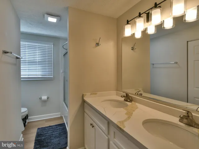 a bathroom with a sink double vanity granite tub and a mirror