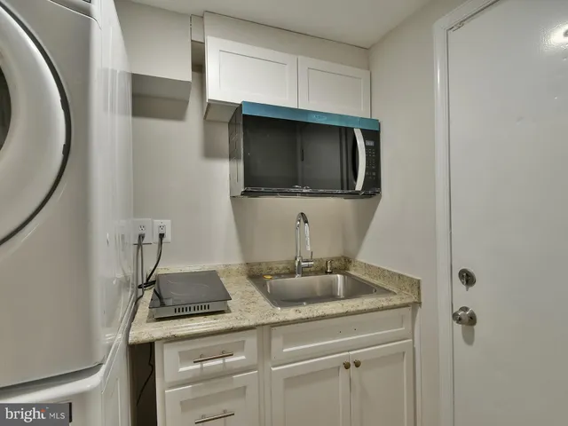 a bathroom with a granite countertop sink a mirror and vanity