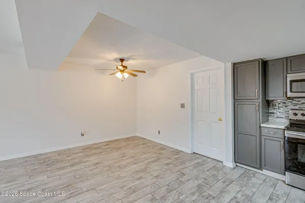 a view of kitchen with granite countertop cabinets and refrigerator