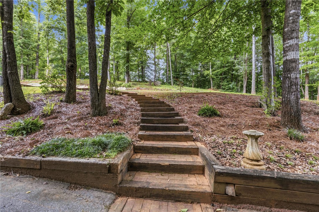 641 Lands End Road Seneca, SC 29678 - Photo 32 of 39 An inviting wood-stepped pathway ascends a gently sloping, tree-lined landscape.
