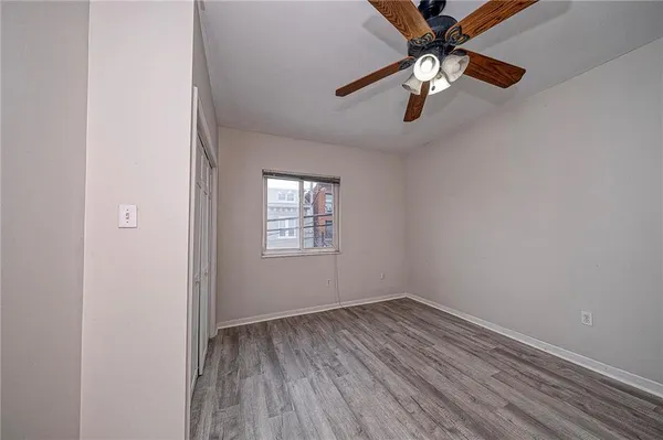 an empty room with a window and a fan