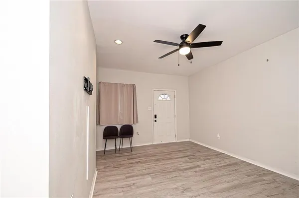a view of a livingroom with a ceiling fan and wooden floor
