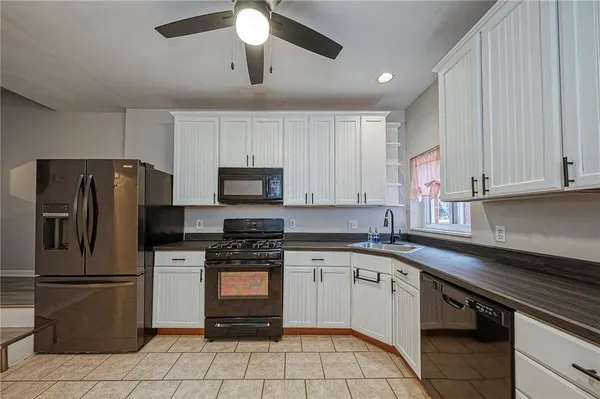 a kitchen with white cabinets stainless steel appliances and a counter space