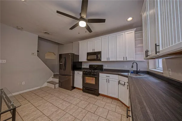 a kitchen with stainless steel appliances granite countertop a sink and a stove