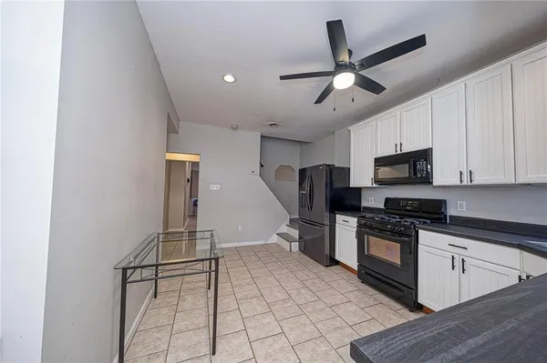 a kitchen with stainless steel appliances granite countertop a refrigerator a stove a microwave oven a sink with island and chairs