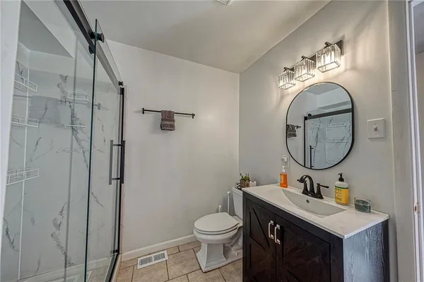 a bathroom with a toilet a sink and mirror
