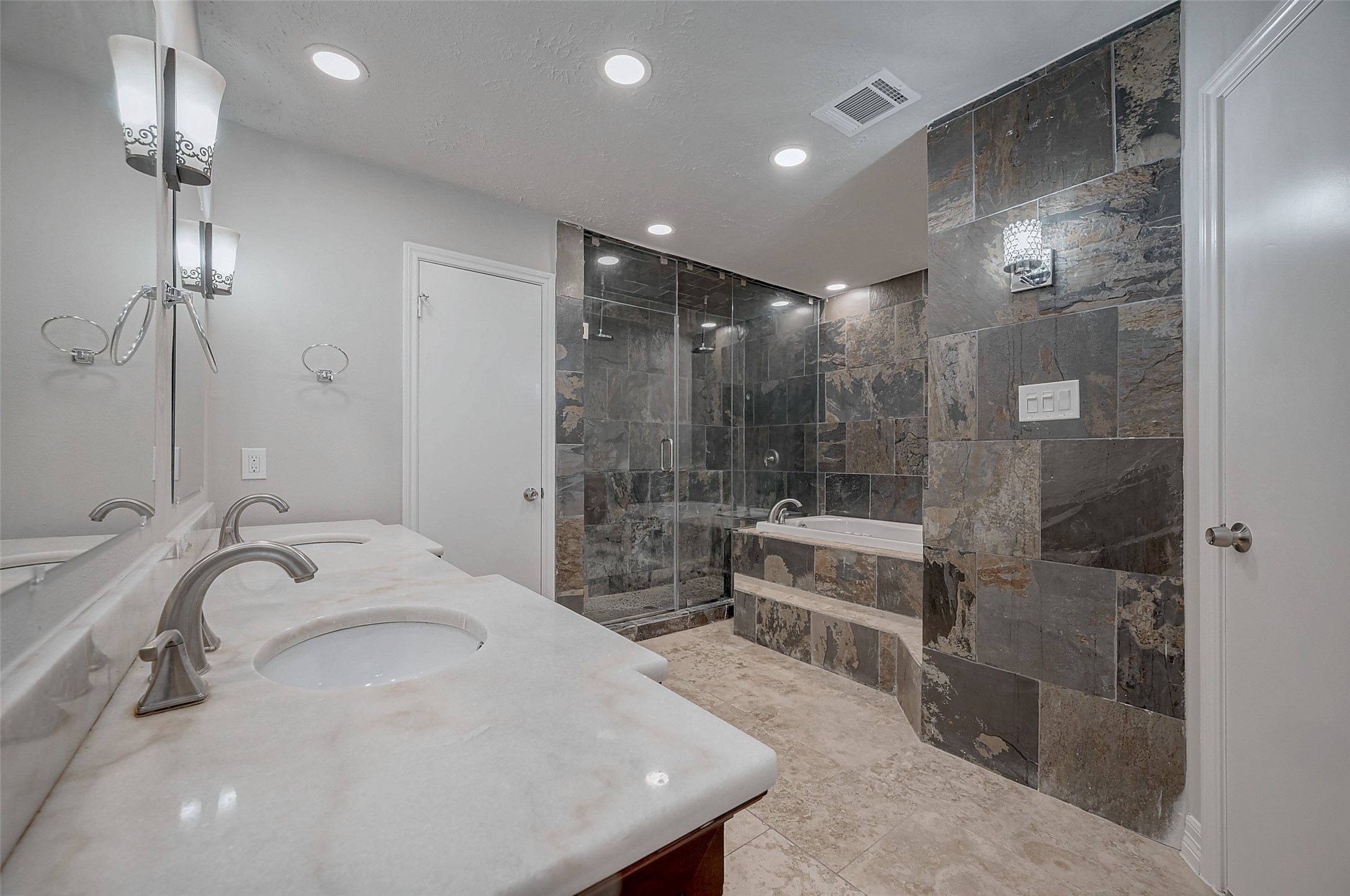 919 Mockingbird Way Sugar Land, TX 77478 - Photo 16 of 41 Primary bathroom features a sleek design with a stone-tiled shower and bathtub.