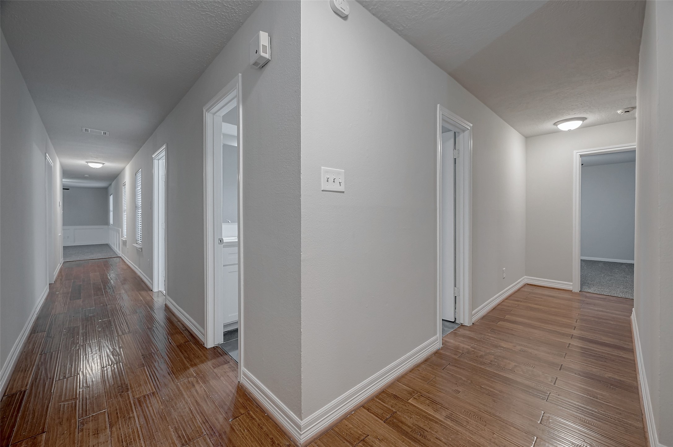 919 Mockingbird Way Sugar Land, TX 77478 - Photo 22 of 41 A well-lit, spacious hallway with polished wood floors and multiple doorways.