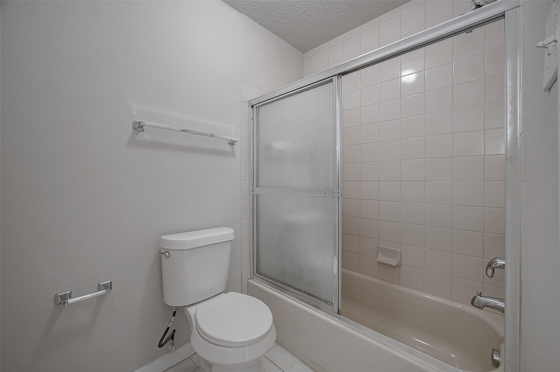 919 Mockingbird Way Sugar Land, TX 77478 - Photo 30 of 41 Modern bathroom featuring a sleek tub with glass doors and clean, neutral tiling.