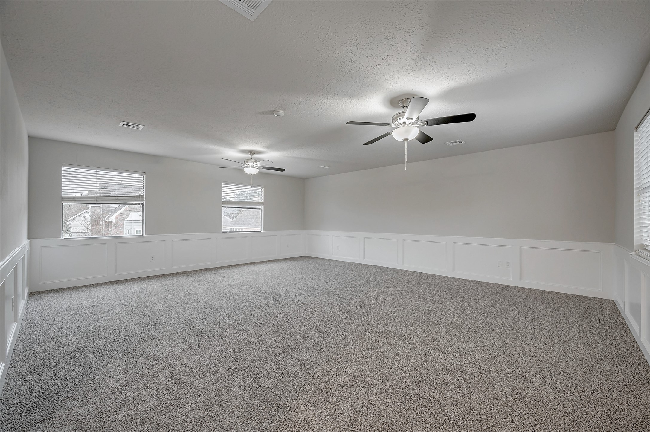 919 Mockingbird Way Sugar Land, TX 77478 - Photo 33 of 41 Room with neutral tones, carpeted flooring, and wainscoting.