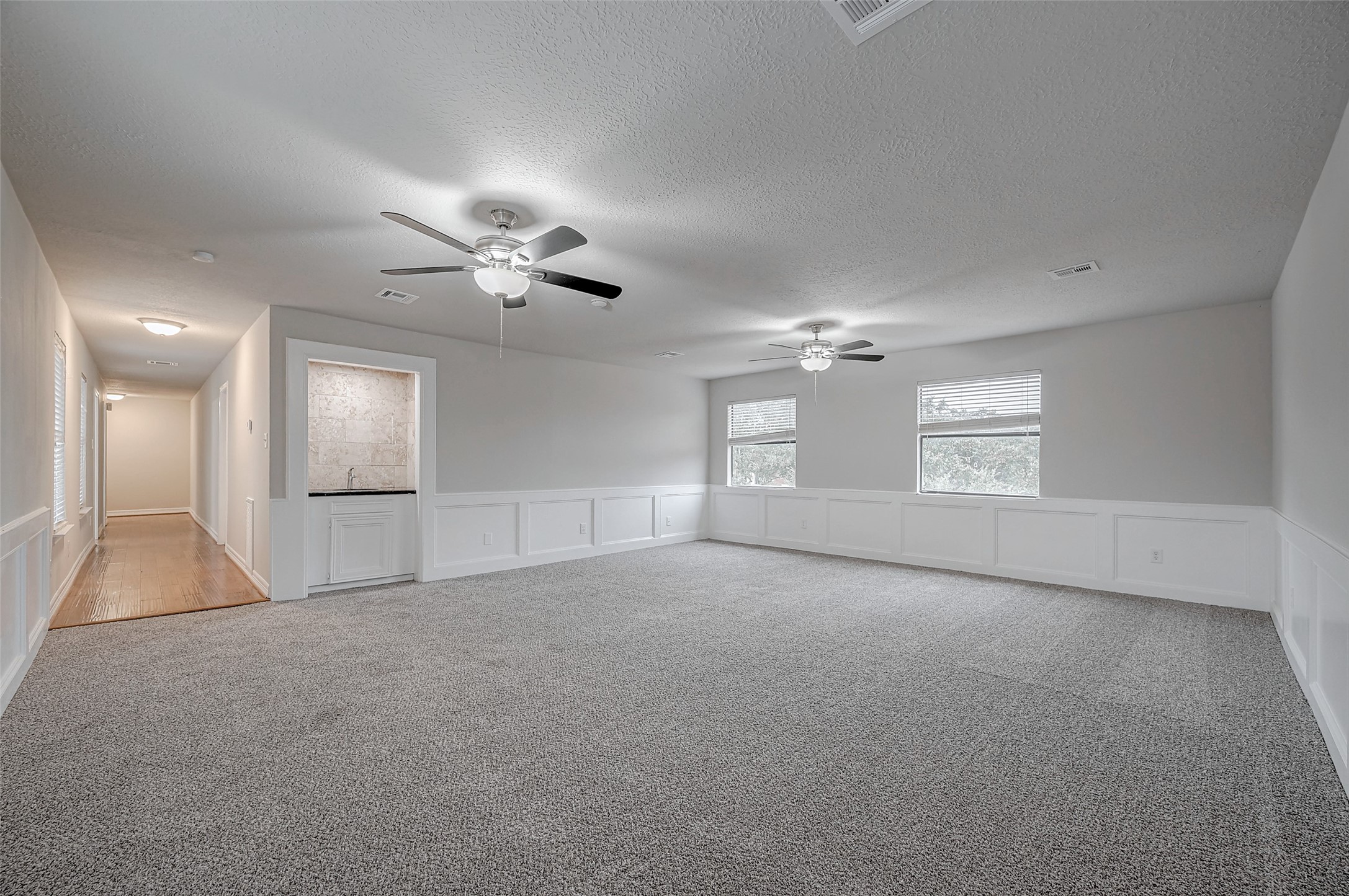 919 Mockingbird Way Sugar Land, TX 77478 - Photo 34 of 41 Family room with neutral walls, and wood-floored hallway extends from the main area.