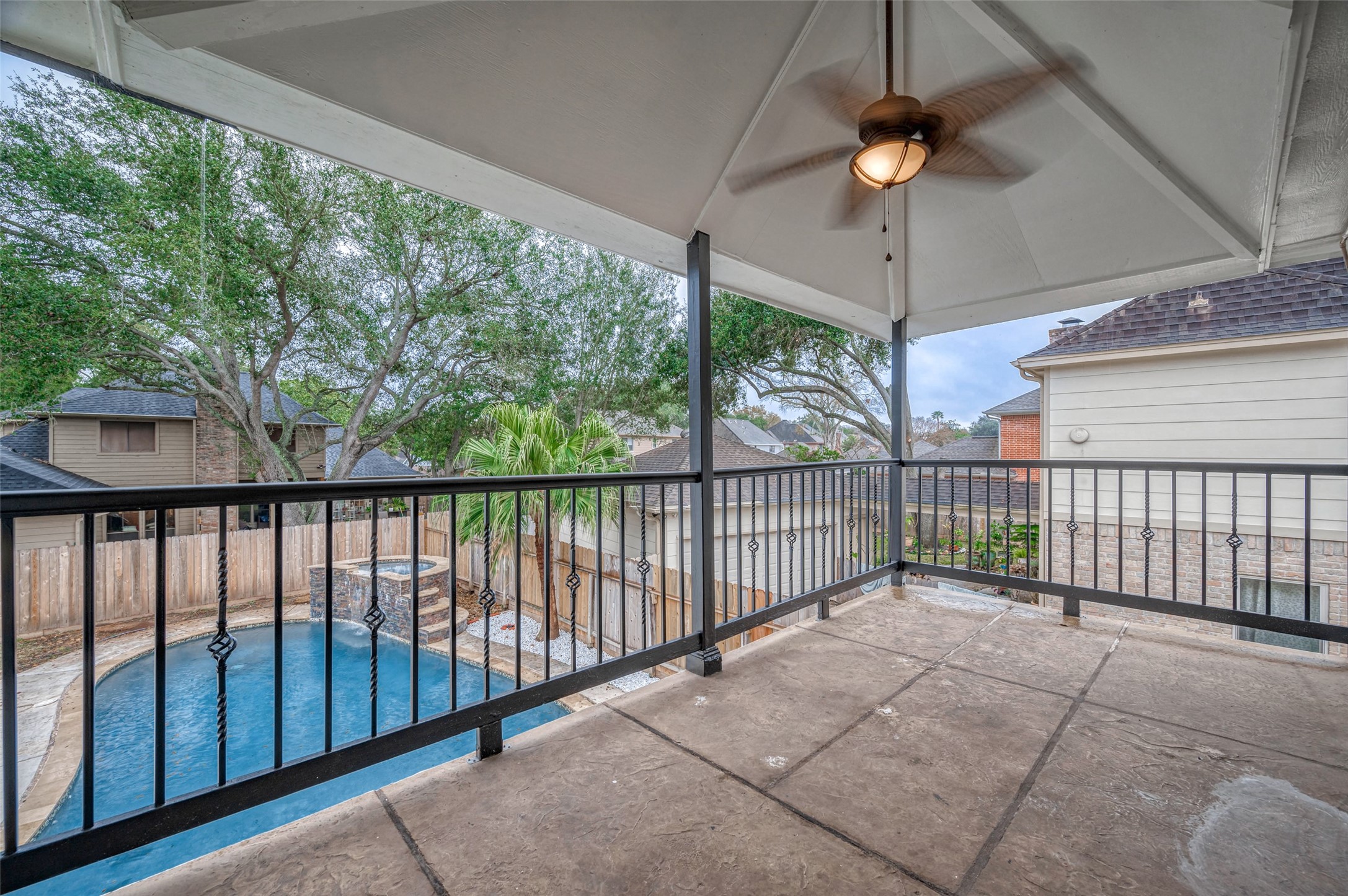919 Mockingbird Way Sugar Land, TX 77478 - Photo 36 of 41 Covered patio area with a ceiling fan and large glass doors leading to a pool area.